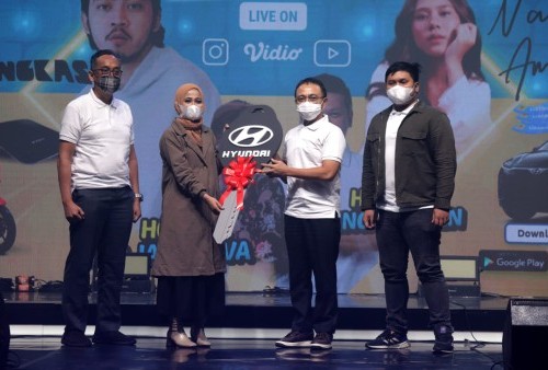 HADIAH UTAMA: Direktur Utama PLN Darmawan Prasodjo menyerahkan hadiah utama mobil listrik kepada sang pemenang Maya Orifta. FAJAR INDONESIA NETWORK