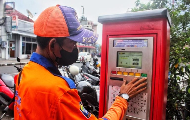 MESIN PARKIR: Seorang petugas tengah mengoperasikan mesin parkir di Jalan Braga Kota Bandung. (Jabar Ekspres)