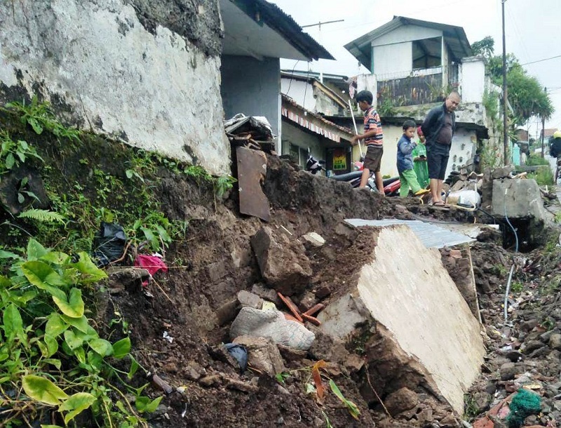 AMBRUK: Tanah longsor sepanjang 10 kali 1,5 meter yang mengupas sebagian tembok penahan tanah dan tembok rumah warga di Kampung Tutugan Cihanjuang Rahayu Parongpong.EKO SETIONO/PASUNDAN EKSPRES